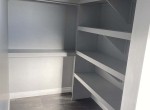 walk-in closet with custom wooden shelving